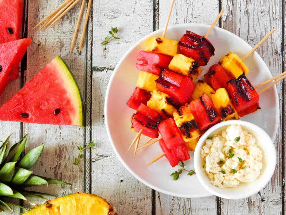Grilled summer watermelon and pineapple fruit kabobs with feta, top view over white wood - Nők Lapja